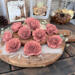 Faux wood flower blossoms hand painted in a dusty pink. Blossoms look like an English rose with layered petals with ruffles edges. 